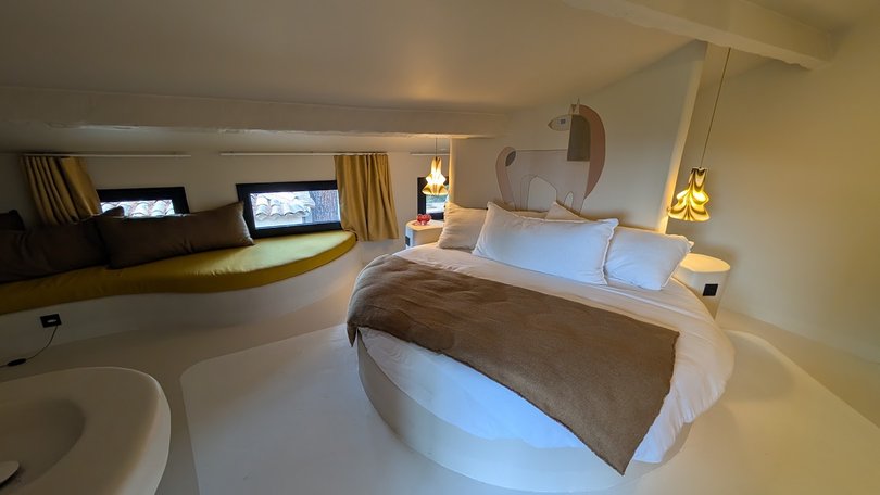 Chambre au lit rond et banquette jaune moutarde